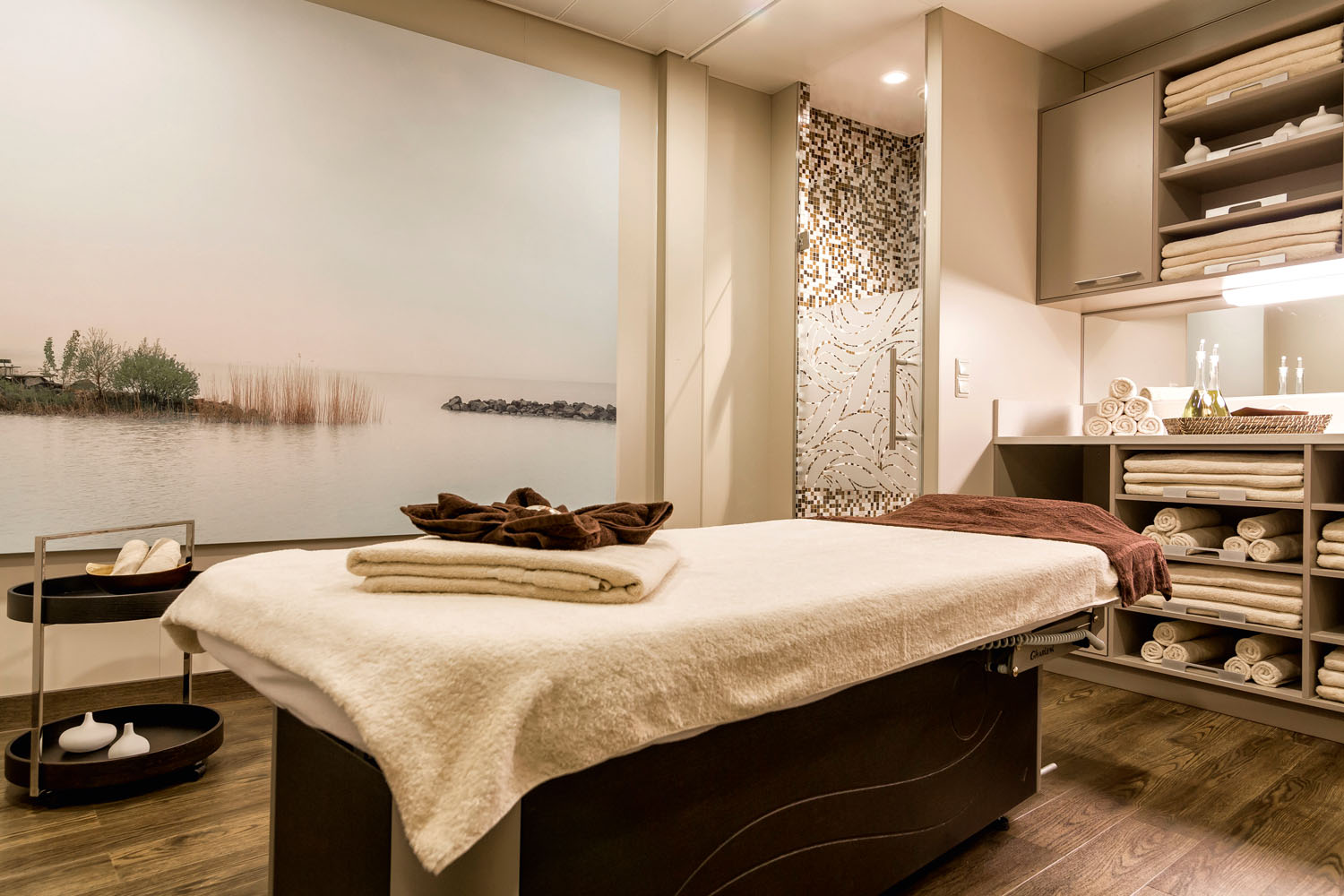 Luxurious spa room with premium Gharieni treatment table, towels, and serene decor.