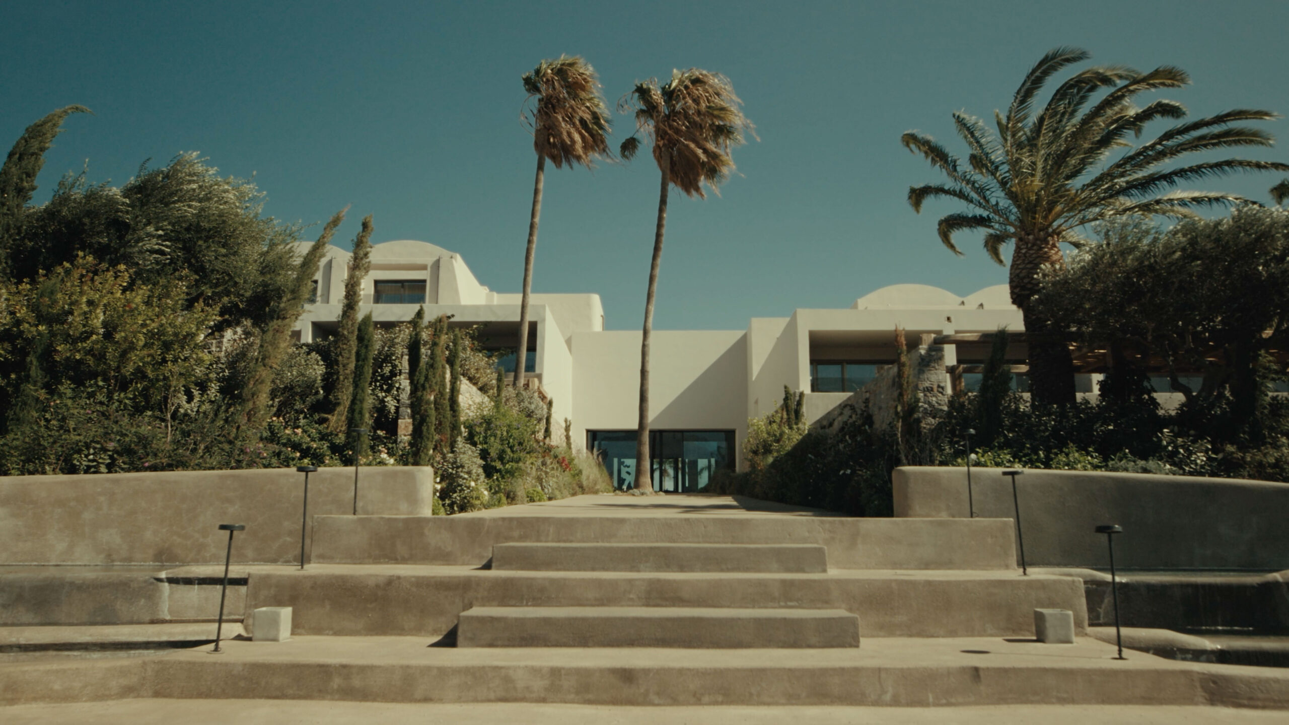 Luxurious spa entrance with palm trees, modern architecture; Gharieni premium wellness.